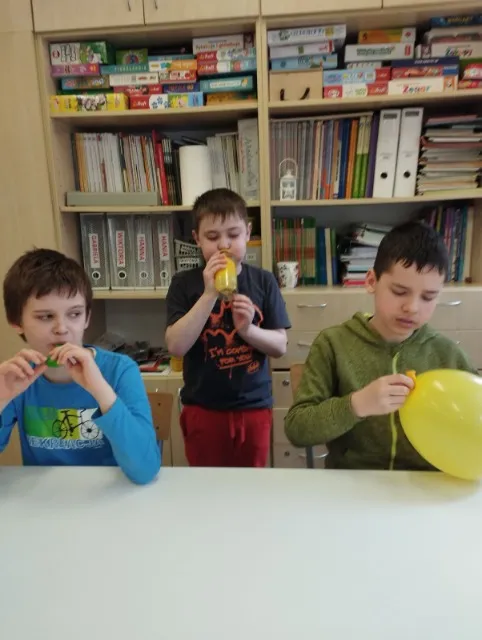 Dzieci wykonują doświadczenia z balonami